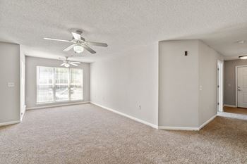 A room with a ceiling fan and carpeted floor.